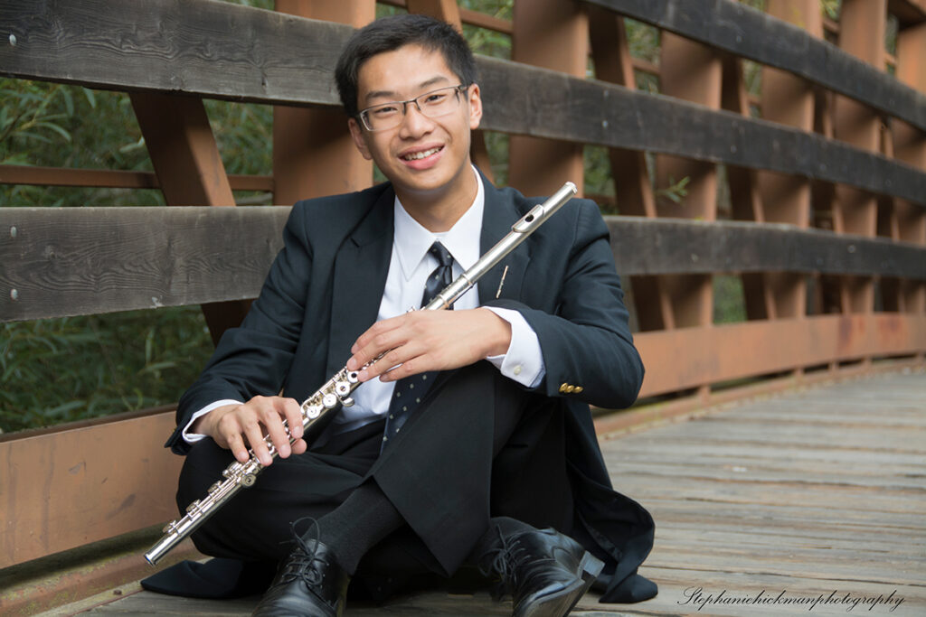 Justin on a bridge holding a flute